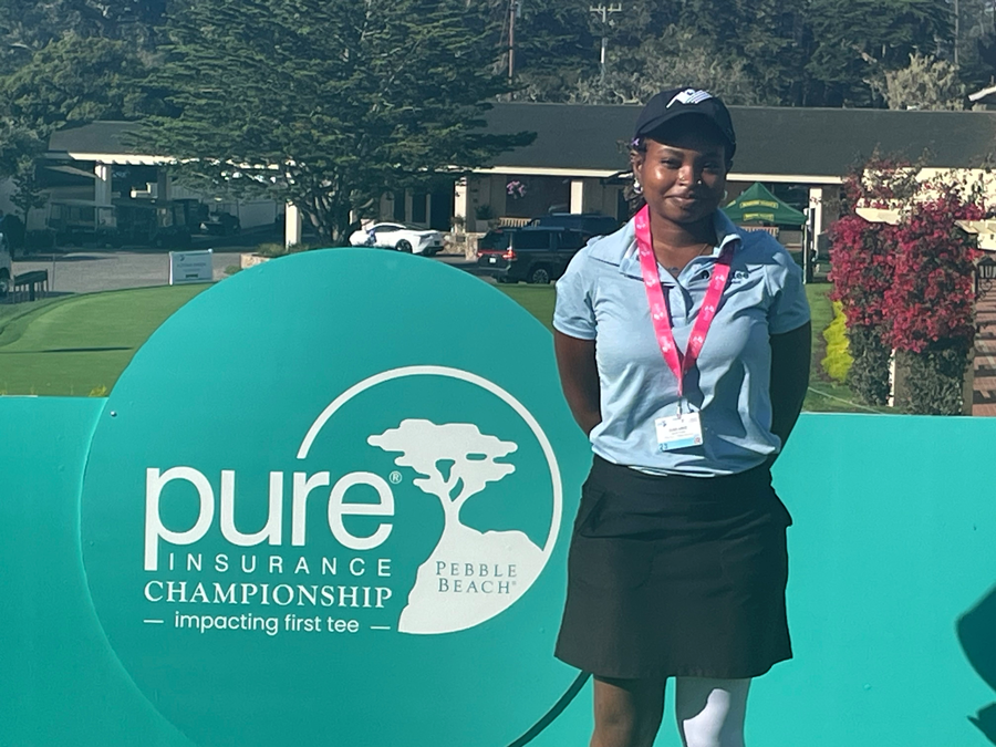 Woman posing by a golf sign
