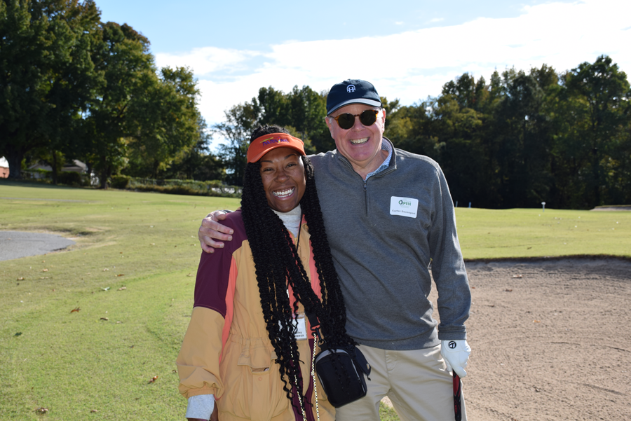 man and a woman standing on a golf green