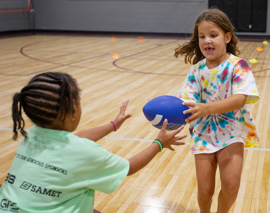 two girls playing with a football